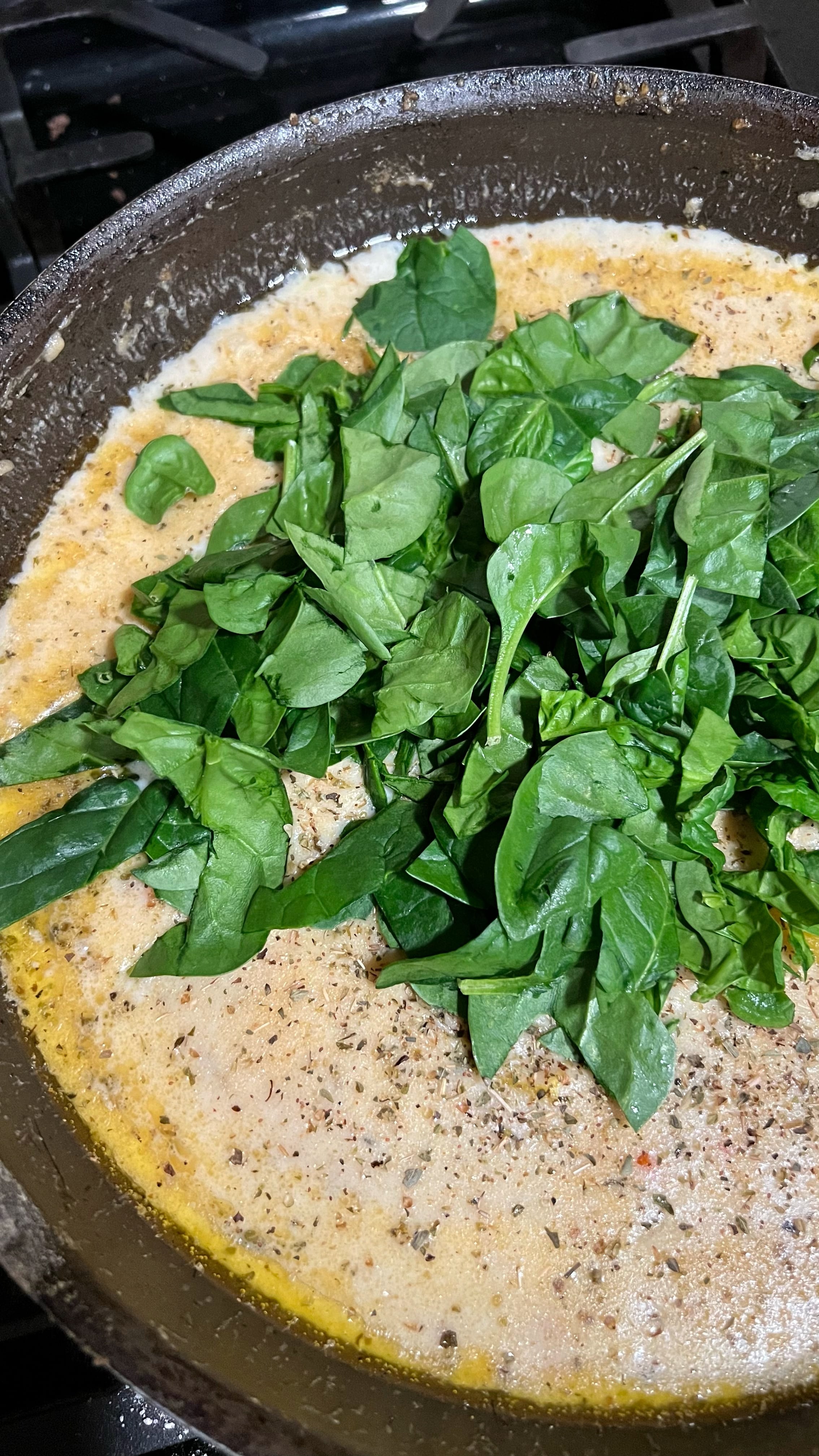 Spinach added to tuscan chicken sauce.